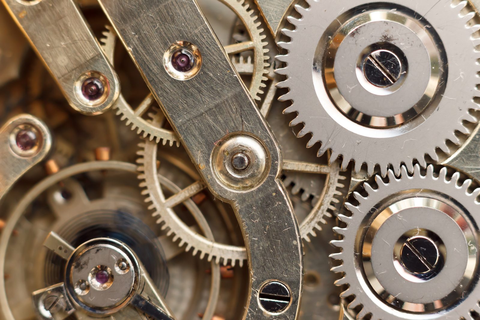 Golden clockwork gears and jeweled bearings inside a watch movement